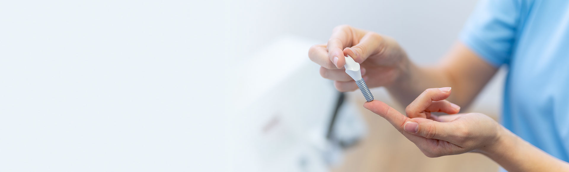 hochwertige-implantate-dauerhafter-zahnersatz Zahnärztin erklärt die Funktionsweise eines Implantats anhand eines Modells